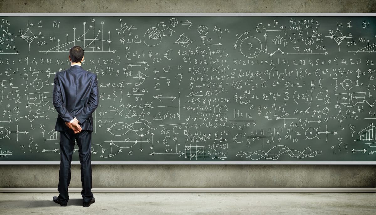 Business person standing against the blackboard