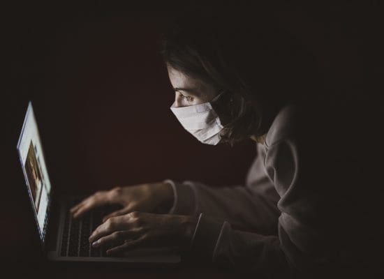 Frau mit PC und Maske